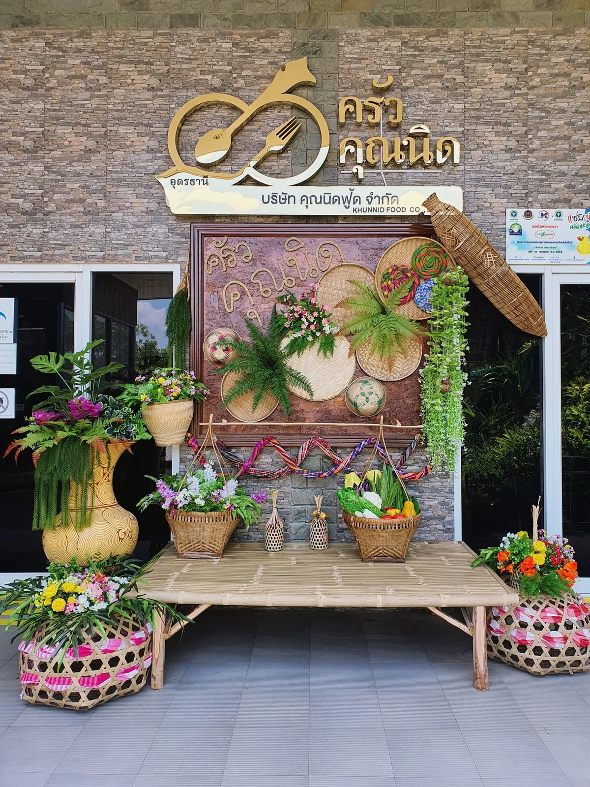 The entrance of Krua Khun Nid, with its gold sign and woven baskets
