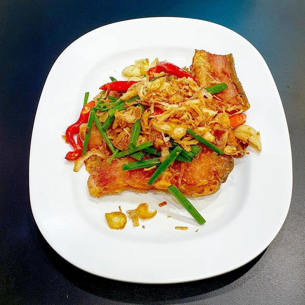 Crisp fried fish topped with garlic, shallots and chillies at Krua Khun Nid